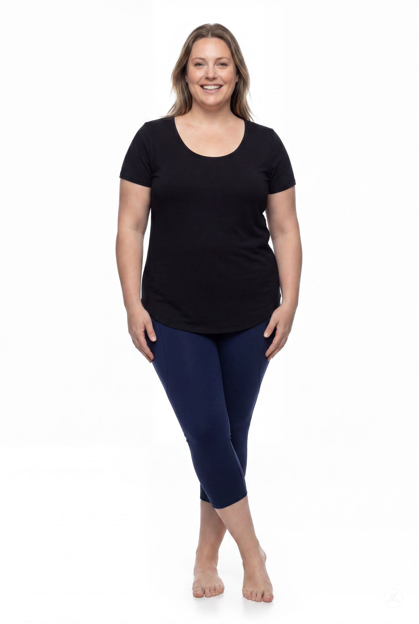Smiling woman standing barefoot wearing SweetLegs Still Water Pocket Crops navy high-waisted leggings front view
