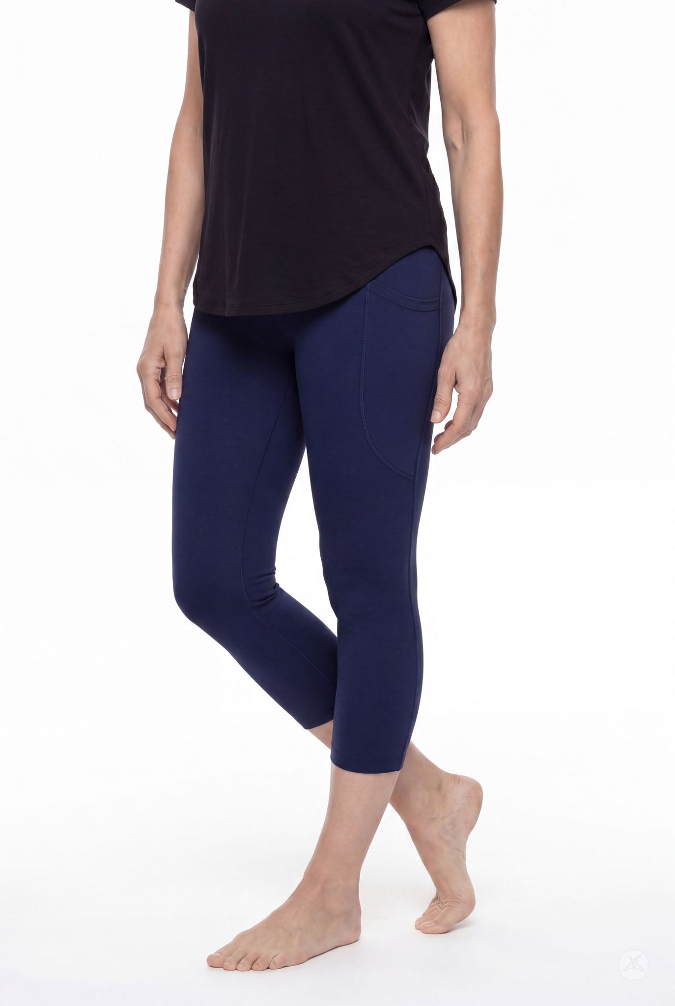 Woman standing barefoot wearing SweetLegs Still Water Pocket Crops navy high-waisted leggings side view