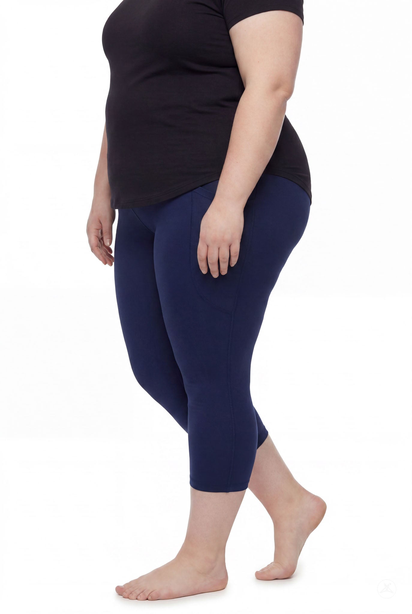 Plus size woman barefoot wearing SweetLegs Still Water Pocket Crops navy leggings with black top side view