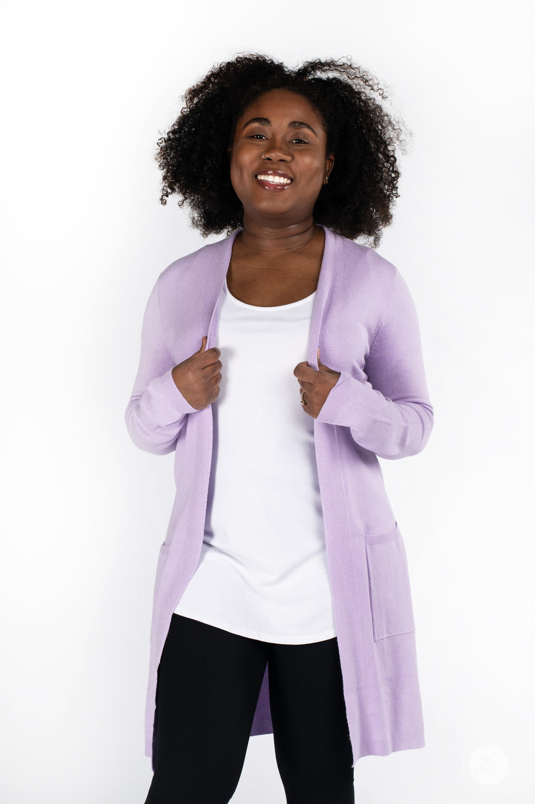 Smiling woman wearing SweetLegs Canada Spring Cardigan in soft lavender with front patch pockets over white top and black pants