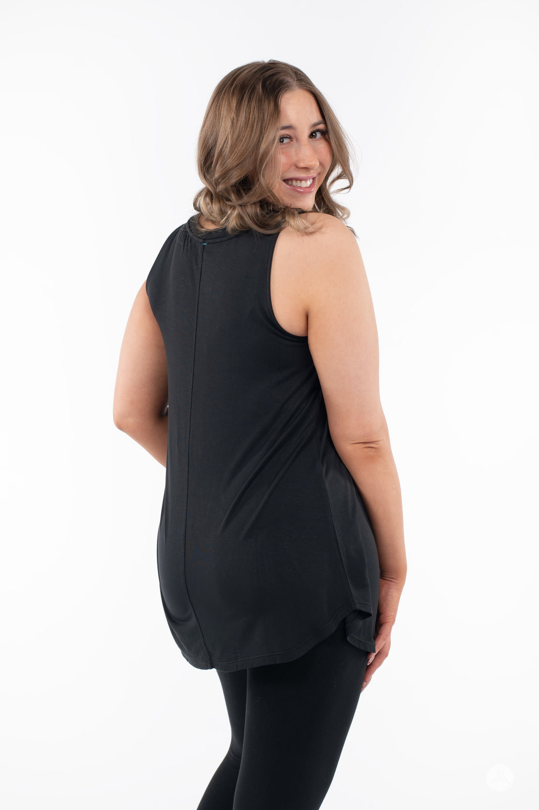 Plus-size woman smiling wearing SweetTops High Neck Swing Tank in black shown from back on white background