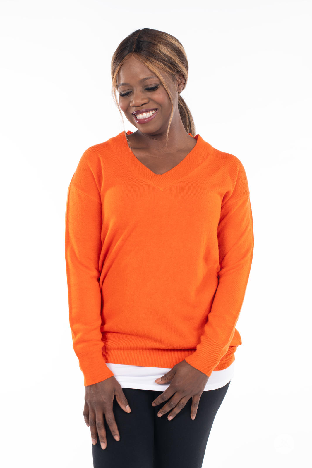 Woman smiling wearing SweetTops Soft Knit V-Neck Sweater in autumn orange with relaxed fit and ribbed cuffs