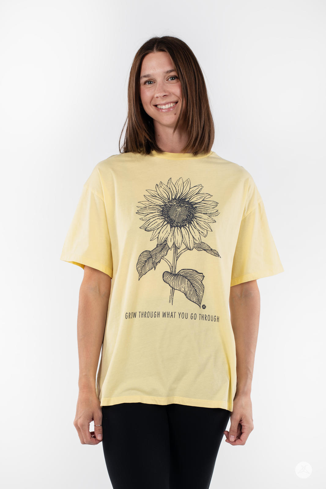 Woman smiling wearing SweetTops Vintage Graphic Tee in pale yellow with sunflower illustration and affirmation text