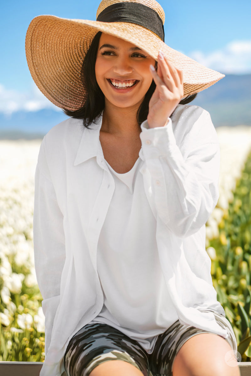 Smiling woman outdoors wearing SweetTops Classic Linen Shirt in white with long sleeves and relaxed fit