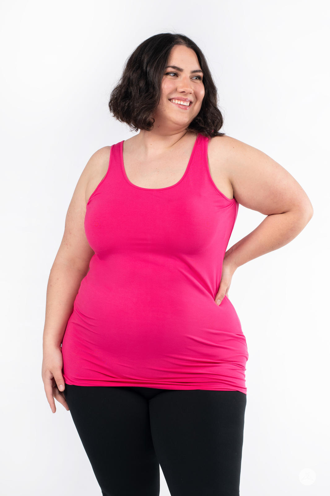 Plus size woman smiling wearing bright pink Classic Layering Tank by SweetLegs Canada with black leggings on white background