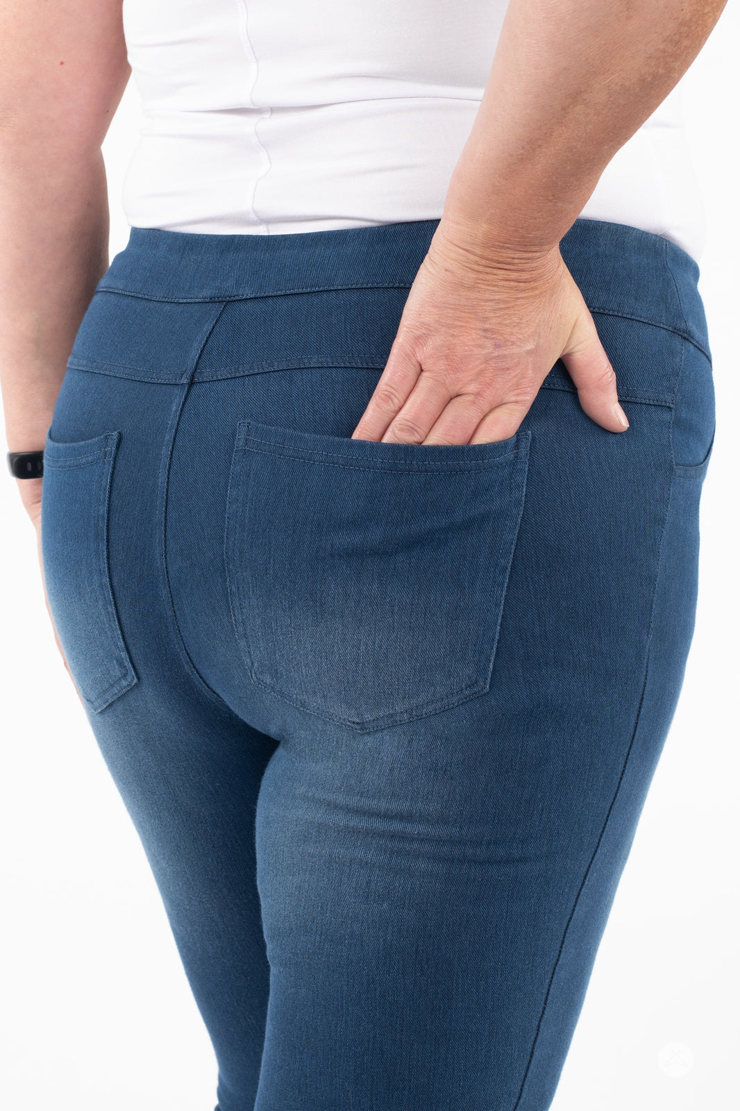 Back view of plus-size model wearing SweetLegs Denim High-Waisted Pocket Leggings in blue with real back pockets and soft stretch
