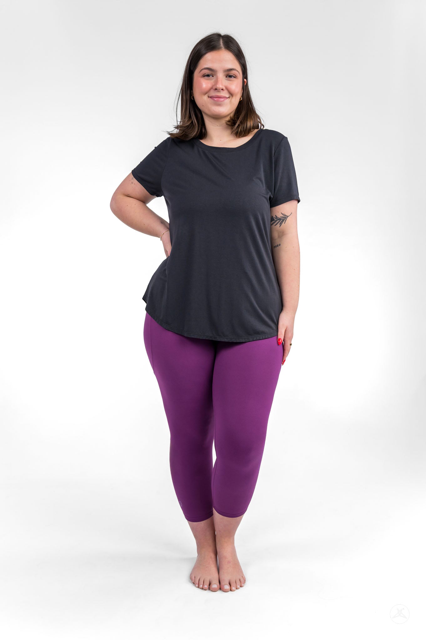 Woman wearing Deep Plum Pocket Crops by sweetlegs paired with a relaxed black short-sleeve top on white background