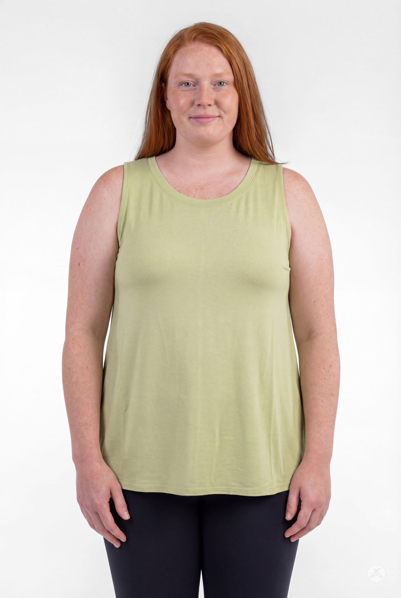 Plus size woman smiling wearing sleeveless light green High Neck Tank by sweettops standing relaxed facing forward