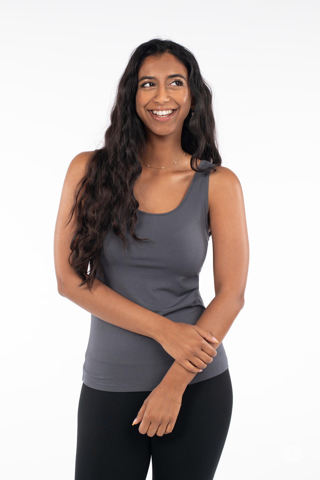 Smiling woman wearing charcoal Classic Tank by SweetLegs Canada with long wavy hair against white background