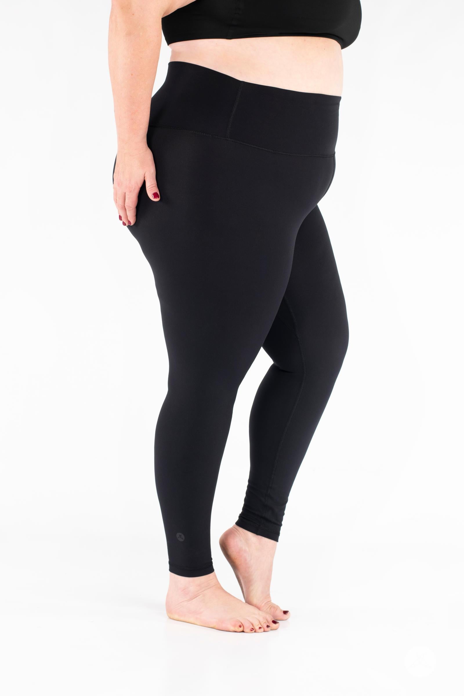 Plus-size model side view wearing black Free Motion Leggings by SweetLegs Athleisure standing barefoot