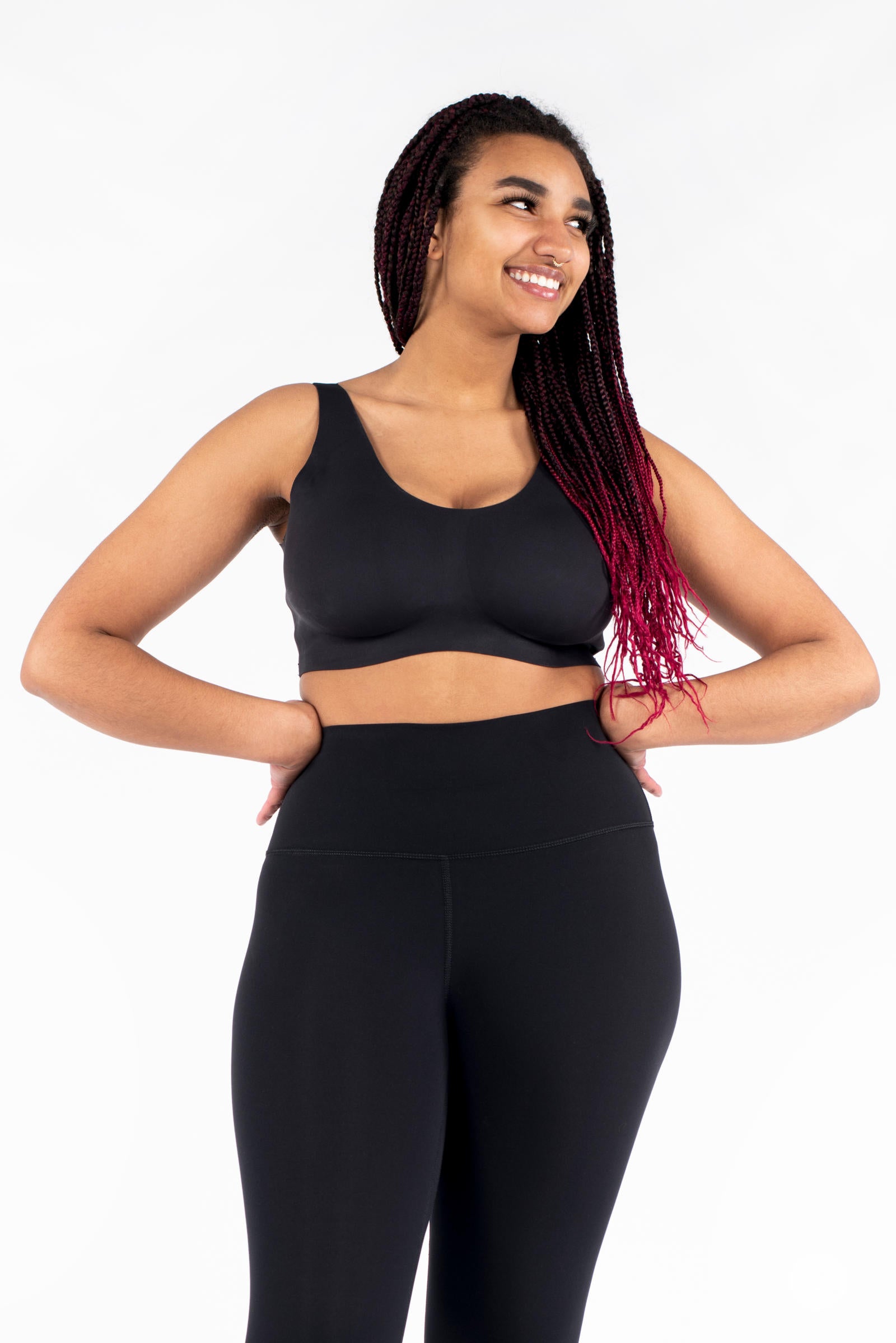 Smiling woman posing with hands on hips wearing black Free Motion Crops by Athleisure SweetLegs collection