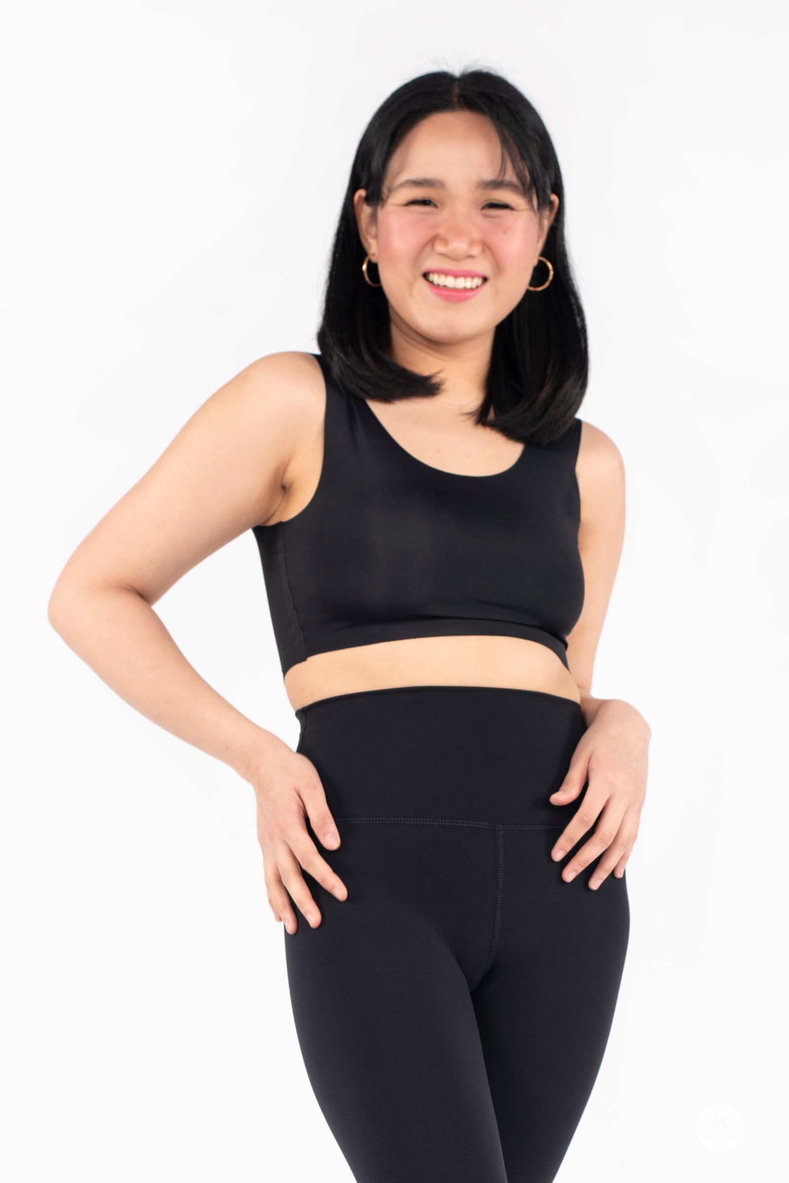 Smiling woman wearing black Free Motion Crops by Athleisure SweetLegs with hands on hips in front view