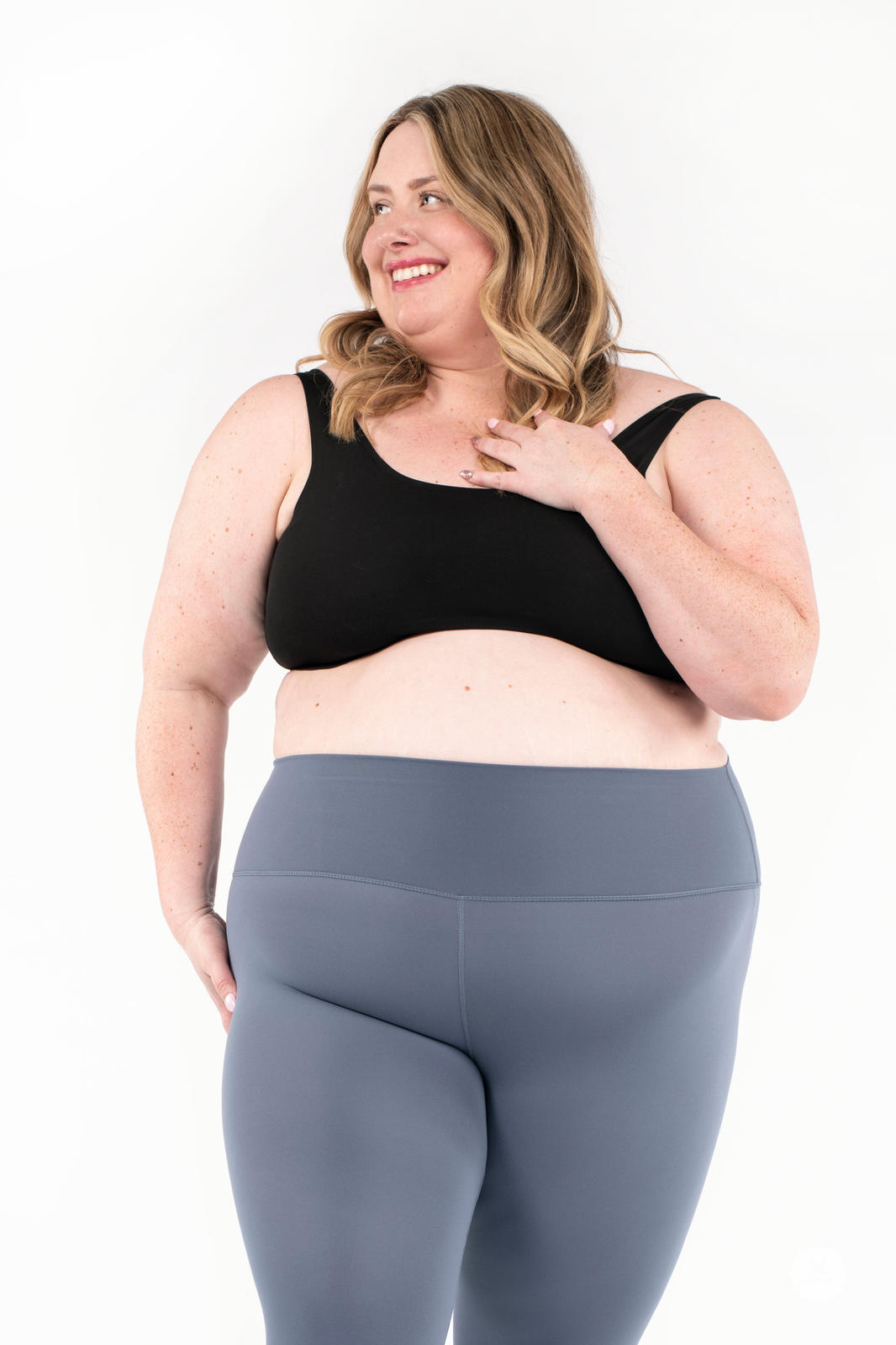 Happy plus-size woman wearing gray Free Motion Crops by Athleisure SweetLegs in a relaxed pose on white background