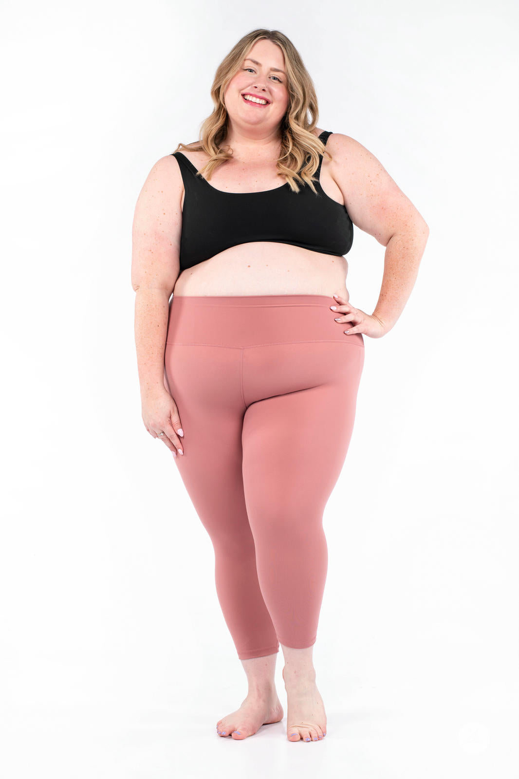 Smiling woman wearing dusty rose Free Motion Crops by Athleisure SweetLegs collection on white background