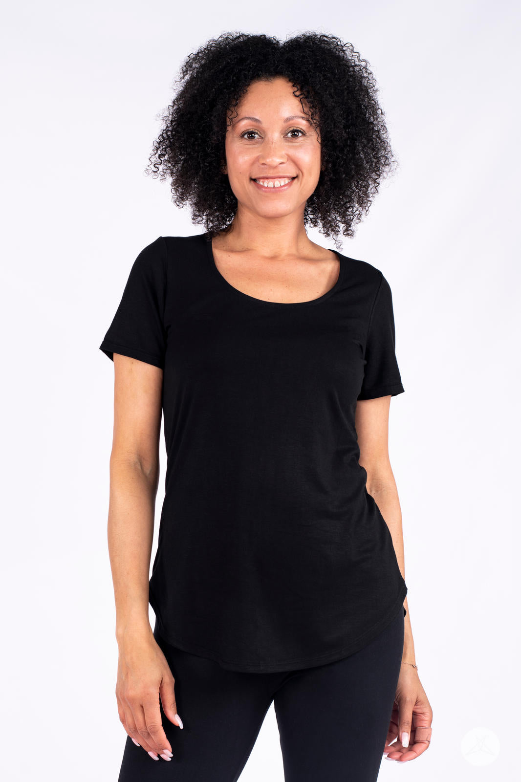 Smiling woman wearing black Classic Tee by SweetLegs Canada with scoop neckline and relaxed fit front view