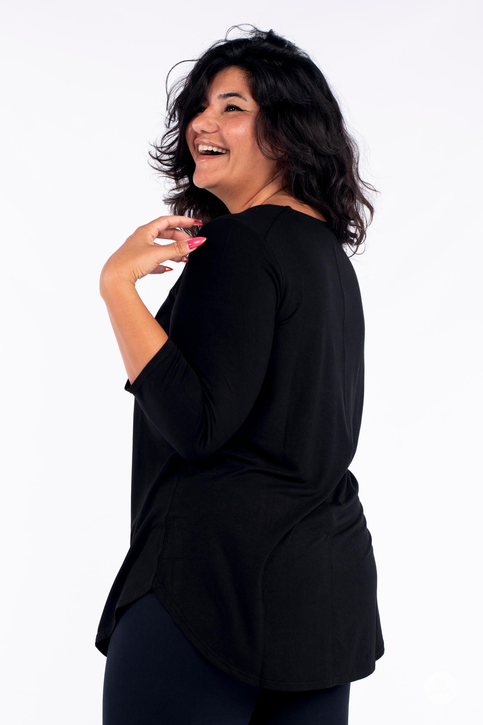 Classic 3/4 Tee by SweetLegs Canada in black with high-low hem and 3/4 sleeves on smiling plus-size model back view