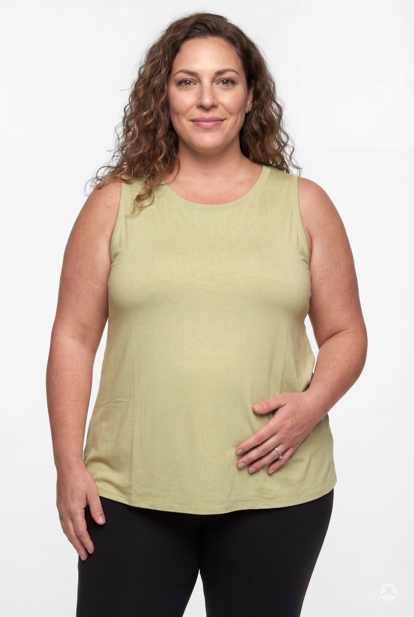 Woman wearing light green High Neck Tank by sweettops with black pants on white background smiling