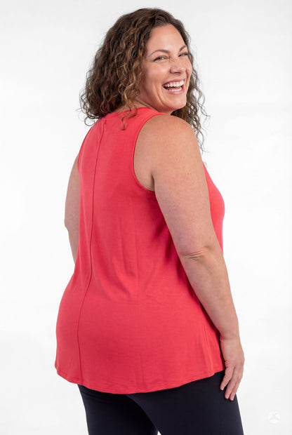 Plus size woman smiling wearing coral sleeveless sleeveless High Neck Tank by sweettops on white background