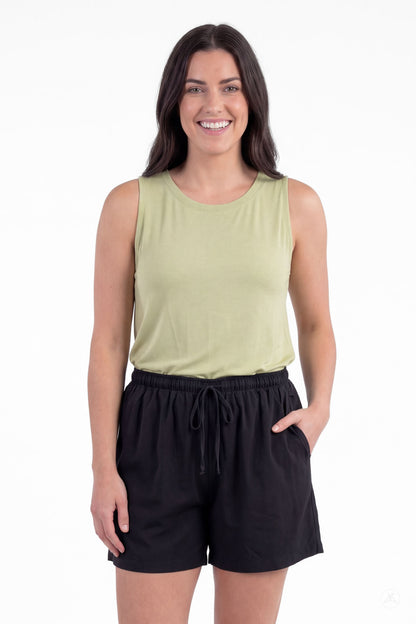 Woman smiling wearing SweetLegs Breeze Shorts in black with elastic waistband and drawstring paired with light green sleeveless top