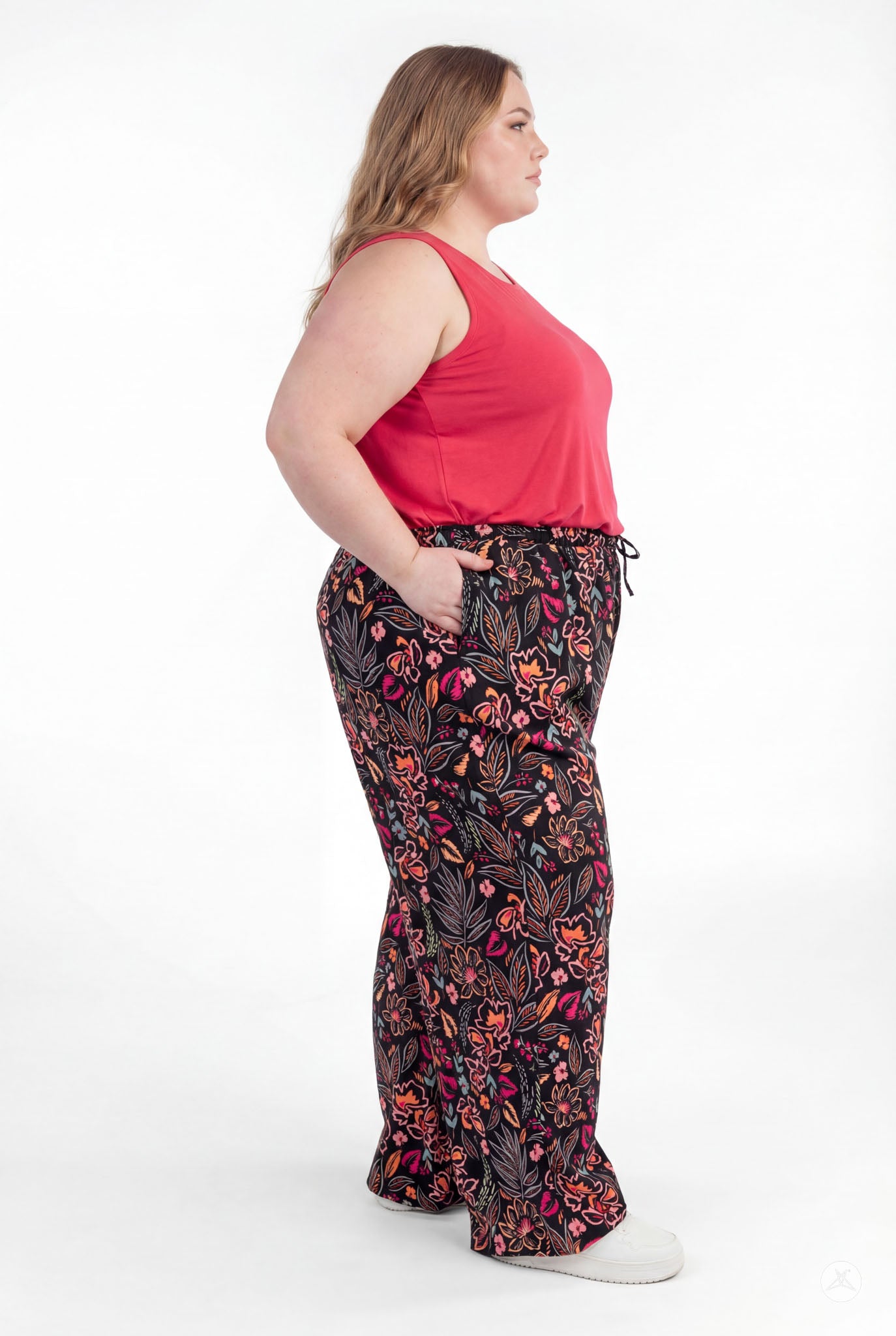 Plus size woman wearing sweetlegs Breeze Wide-Leg Pant with floral print paired with sleeveless red top on white background