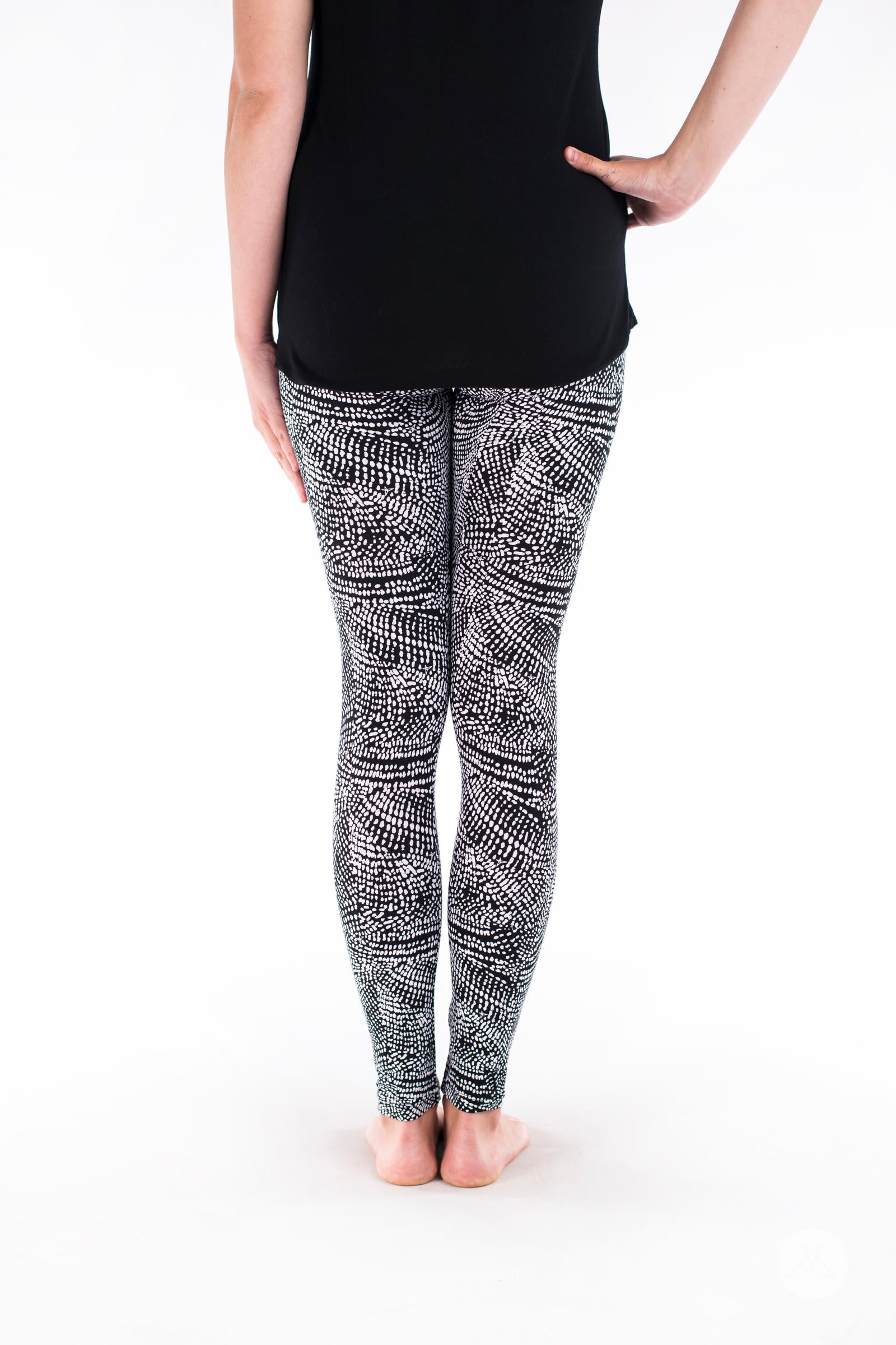 Rear view of SweetLegs Charmed leggings with a black and white abstract snakeskin pattern on model legs