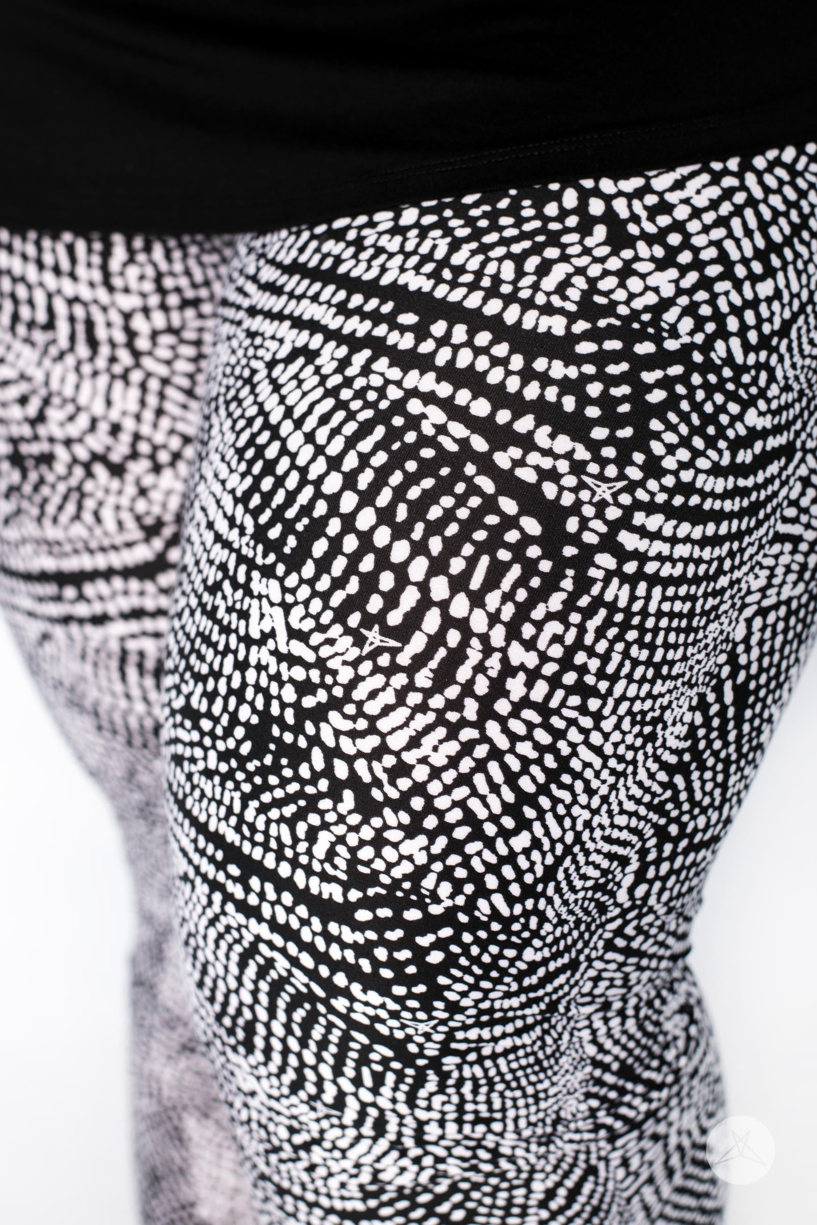 Close-up of SweetLegs Charmed leggings featuring a black and white abstract dotted pattern on model legs