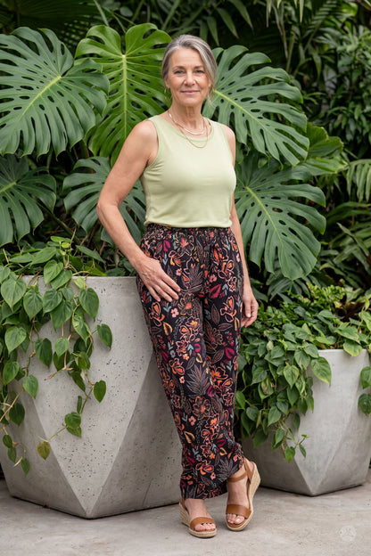Woman standing outdoors wearing sweetlegs Breeze Wide-Leg Pant with floral print and a sleeveless light green top