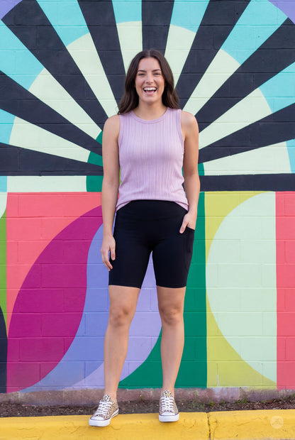 Woman smiling wearing SweetLegs Black High-Waisted Pocket Biker Shorts with hand in pocket front view