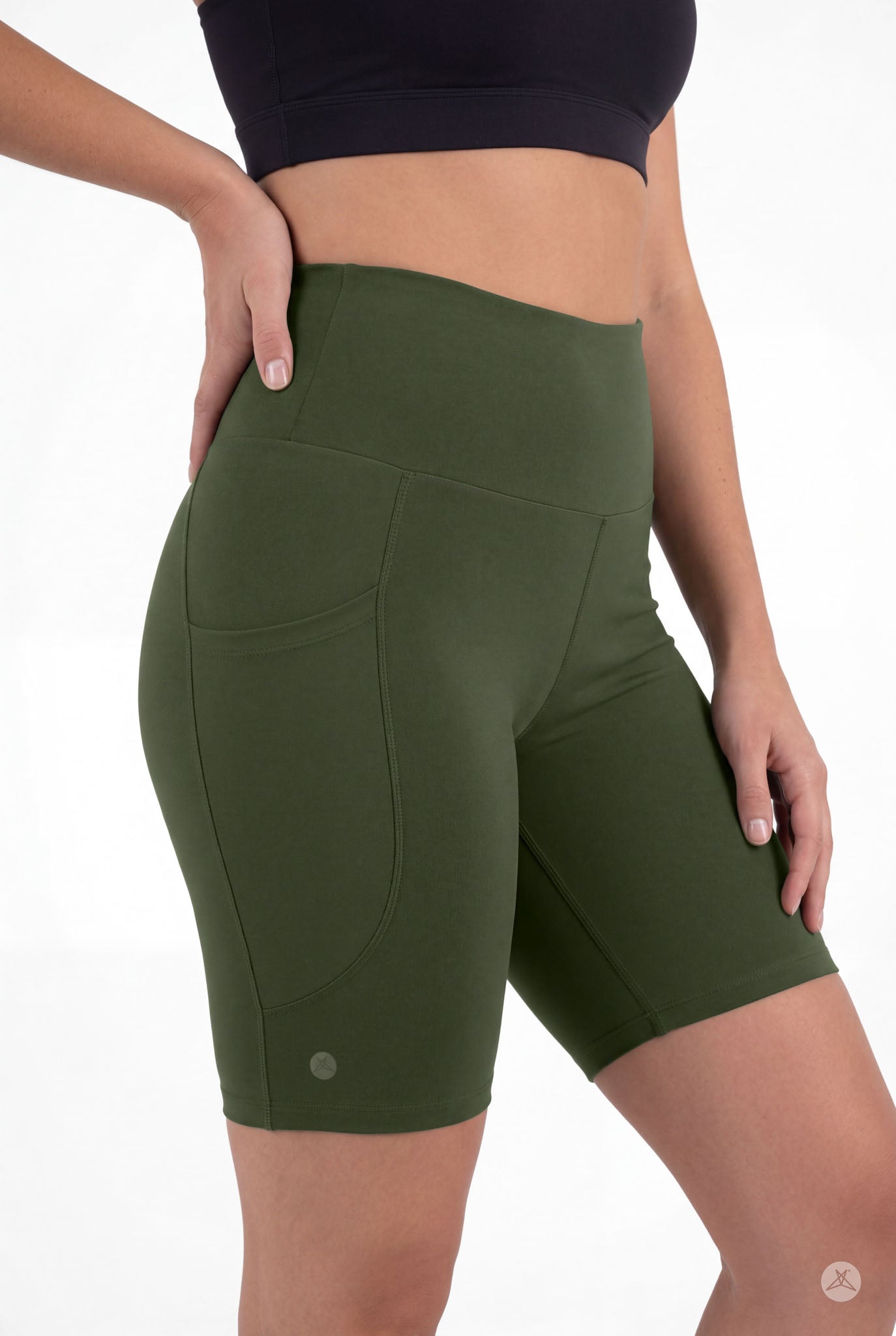 Woman wearing SweetLegs Cedar High-Waisted Pocket Biker Shorts in green with black crop top side view close-up