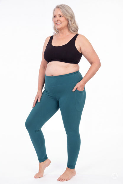 SweetLegs Deep Teal High-Waisted Pocket Leggings worn by a smiling woman in a black top with one hand in the pocket