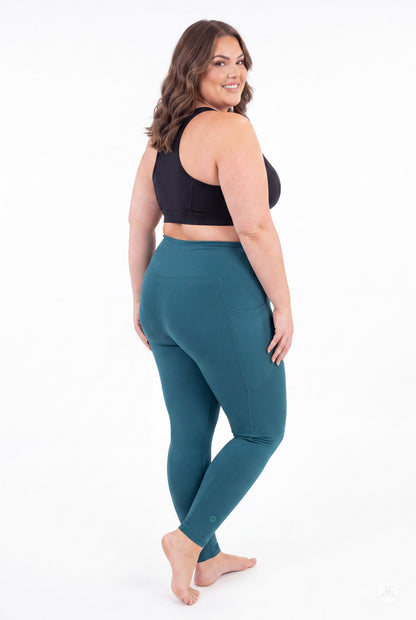 SweetLegs Deep Teal High-Waisted Pocket Leggings modeled from behind by a barefoot woman in a black sports bra