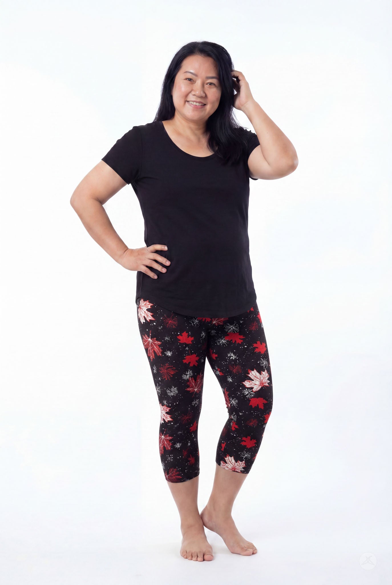 Smiling woman wearing SweetLegs Maple Mood Crops with red and white leaf print and black short sleeve top barefoot