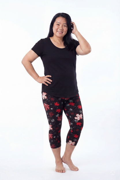 Smiling woman wearing SweetLegs Maple Mood Crops with red and white leaf print and black short sleeve top barefoot