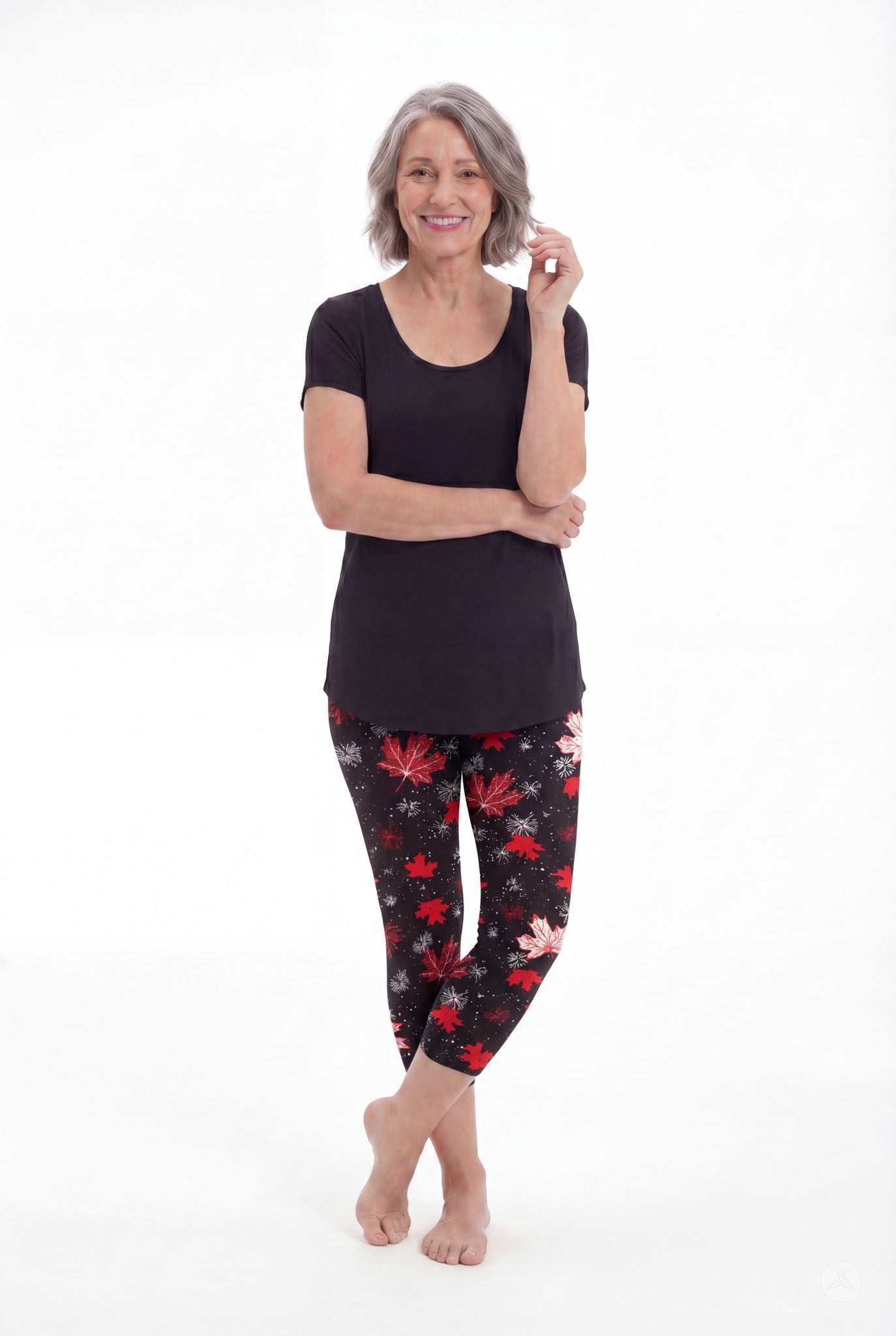 Smiling woman wearing SweetLegs Maple Mood Crops with red maple leaf pattern and black short sleeve top barefoot