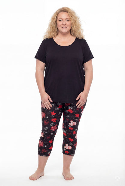Plus size woman wearing SweetLegs Maple Mood Crops with red and white leaf patterns and black short sleeve top barefoot