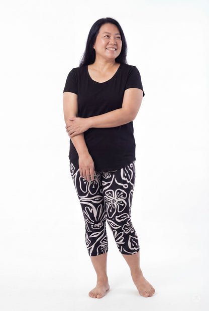 Plus size woman wearing SweetLegs Midnight Bloom Crops with black and white floral pattern and black top barefoot smiling