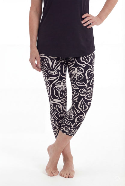 Woman wearing SweetLegs Midnight Bloom Crops with black and beige floral pattern paired with black top barefoot