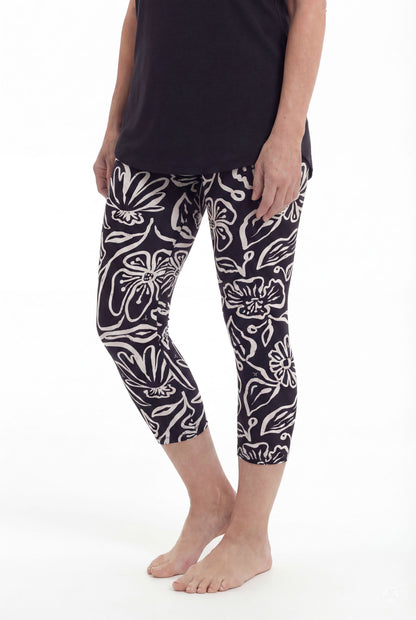Model wearing SweetLegs Midnight Bloom Crops with bold black and white floral pattern barefoot in side pose