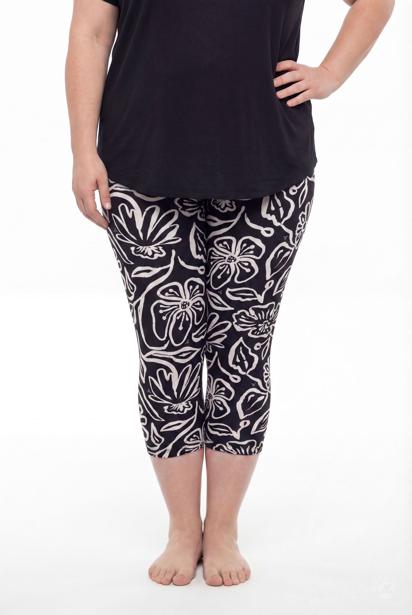 Plus size model wearing SweetLegs Midnight Bloom Crops with black and beige floral pattern and black top barefoot