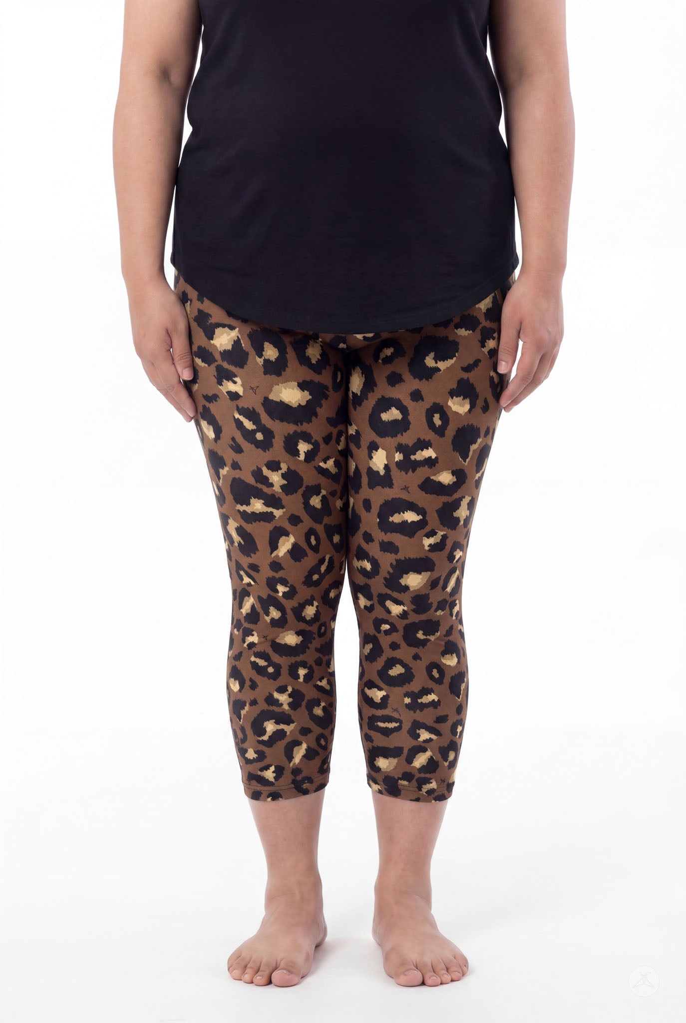 Woman wearing SweetLegs Mocha Spots Crops with brown and black leopard pattern and black top, barefoot standing front view