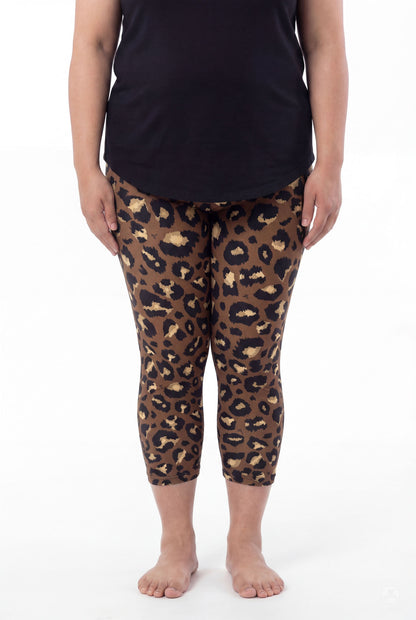 Woman wearing SweetLegs Mocha Spots Crops with brown and black leopard pattern and black top, barefoot standing front view