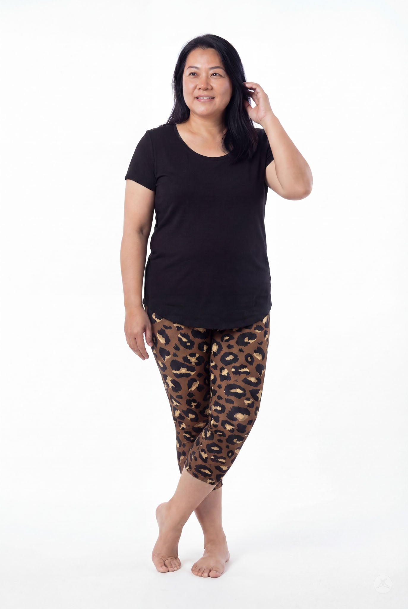 Woman wearing SweetLegs Mocha Spots Crops with brown and black leopard print and black short sleeve top barefoot