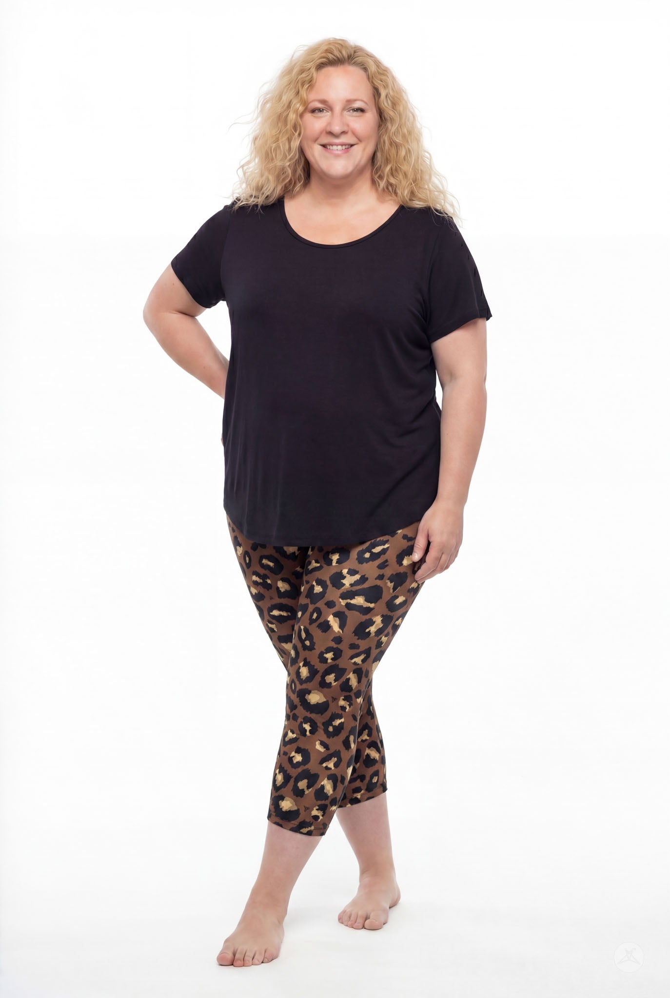 Smiling woman wearing SweetLegs Mocha Spots Crops with brown leopard print and black top barefoot standing full body view