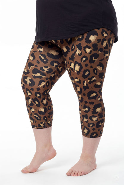 Curvy model wearing SweetLegs Mocha Spots Crops with bold brown leopard print and black top barefoot side view