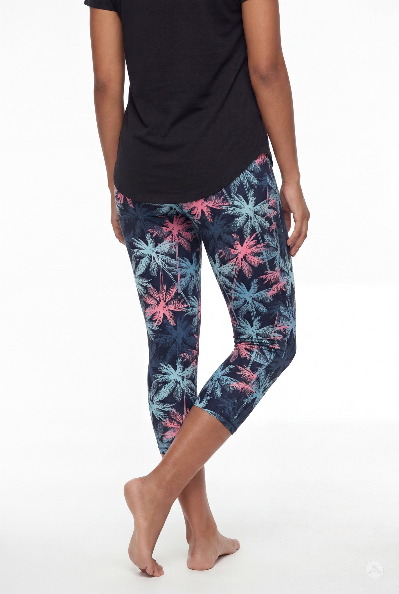 Rear view of woman barefoot wearing SweetLegs Tiki Nights Crops with colorful palm tree pattern and black top