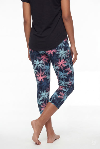 Rear view of woman barefoot wearing SweetLegs Tiki Nights Crops with colorful palm tree pattern and black top