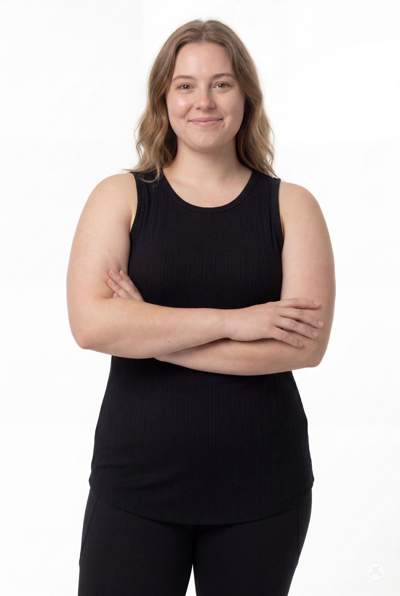 Confident plus size model wearing The Soft Ribbed Tank in black from SweetTops with arms crossed and relaxed smile