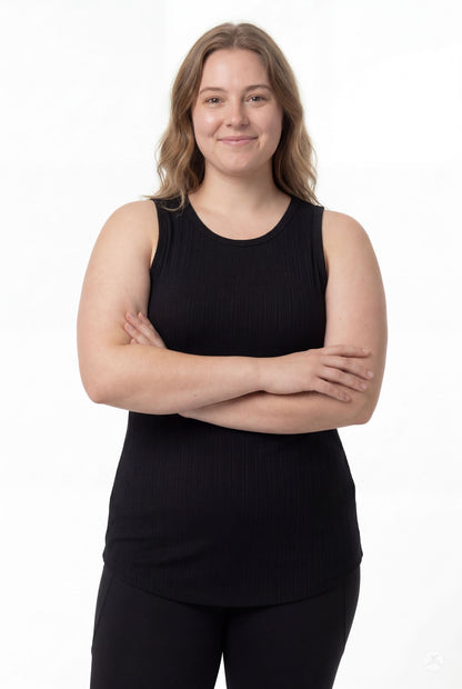 Confident plus size model wearing The Soft Ribbed Tank in black from SweetTops with arms crossed and relaxed smile
