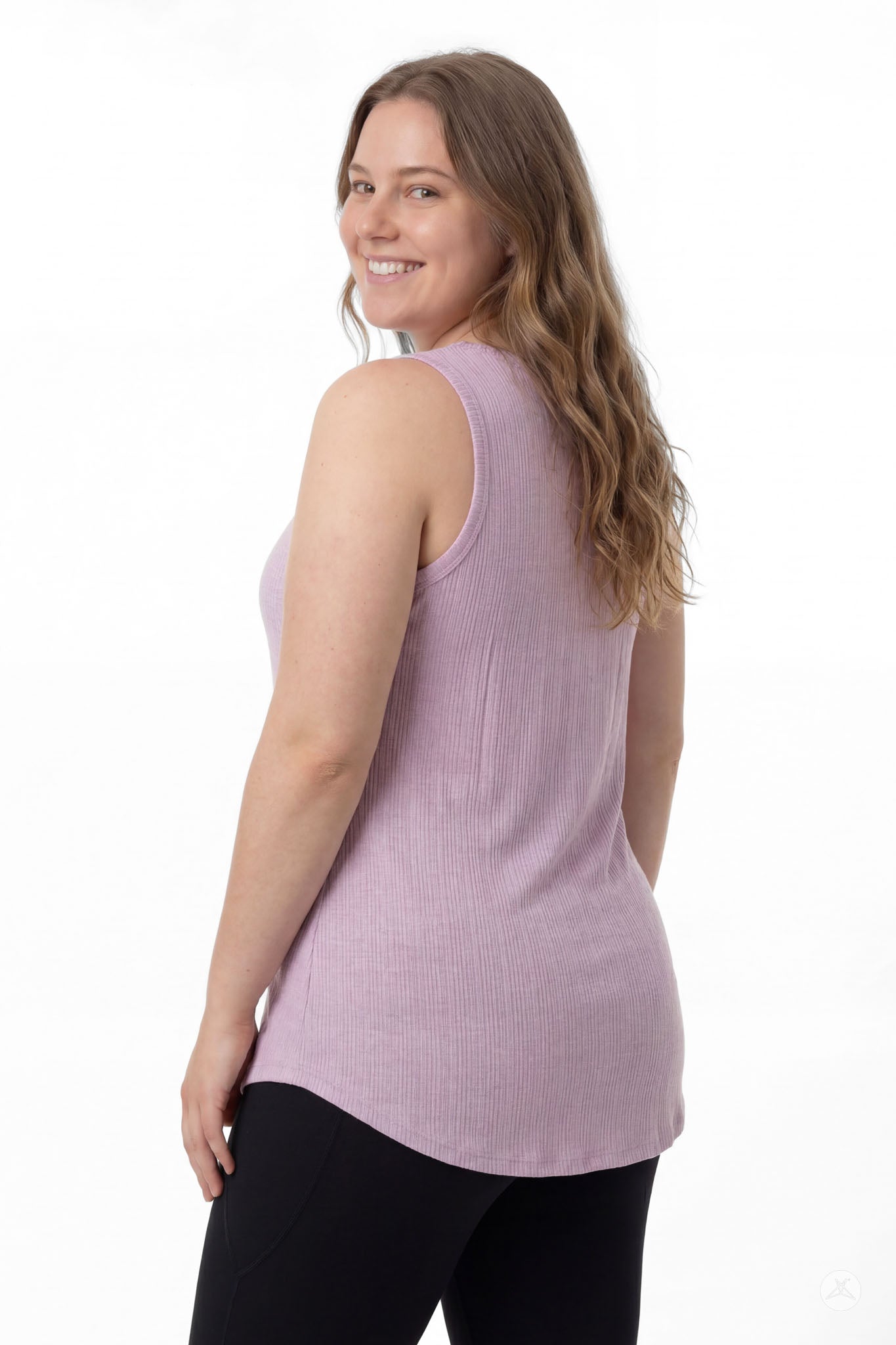 Model wearing SweetTops The Soft Ribbed Tank in lilac, shown from the back with black leggings and smiling confidently