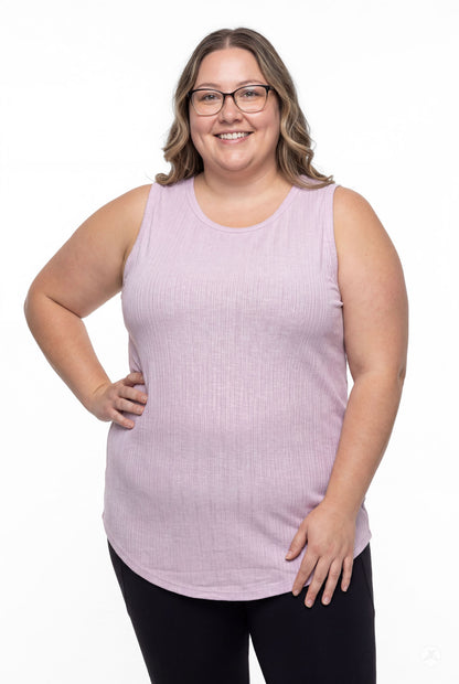 Plus size model smiling wearing SweetTops The Soft Ribbed Tank in lilac with black pants, front view